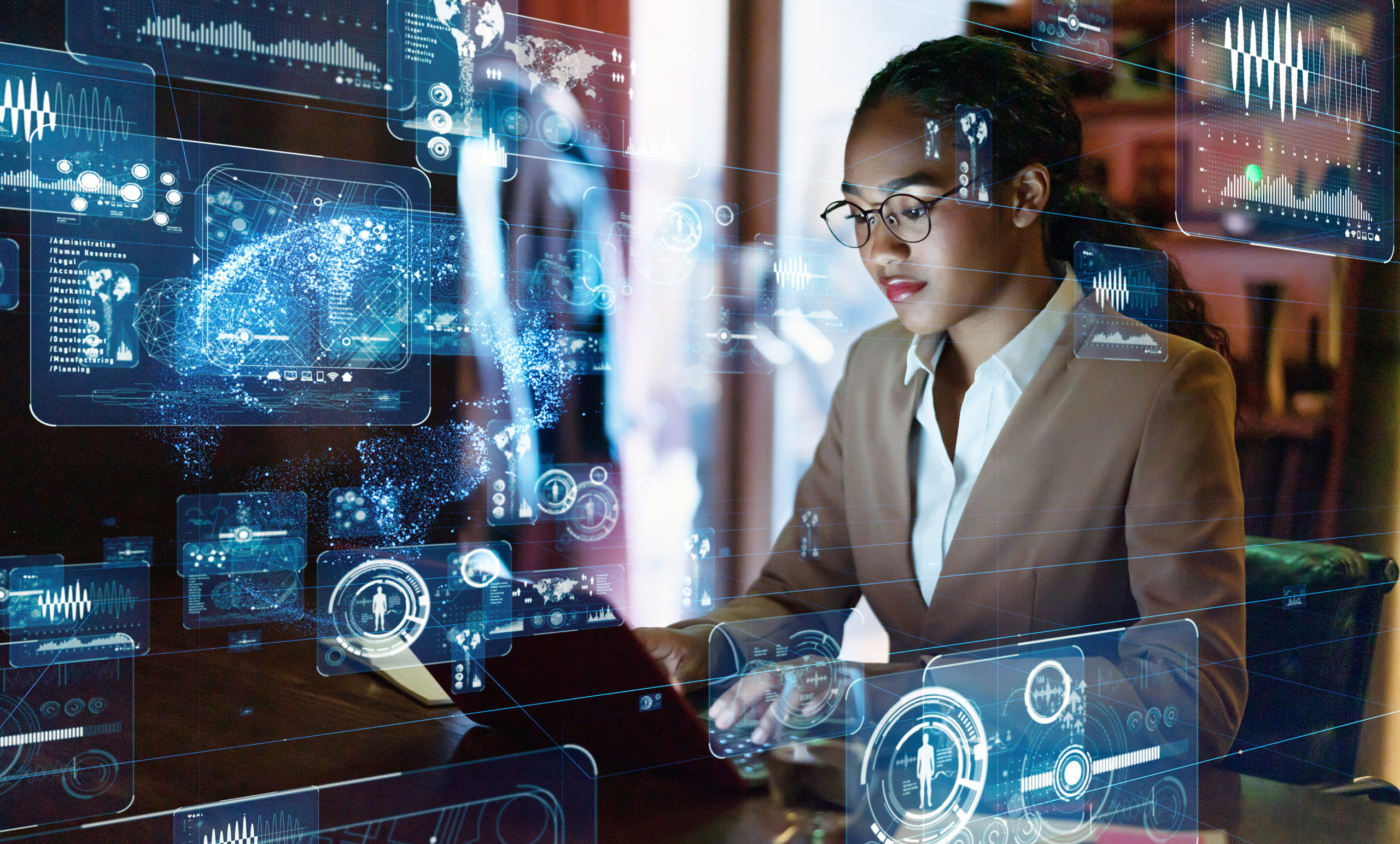 A businesswoman interacts with futuristic holographic technology at her desk.